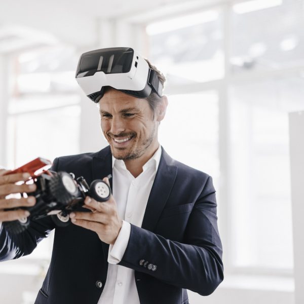 smiling-businessman-wearing-vr-glasses-looking-at-toy-racing-car.jpg